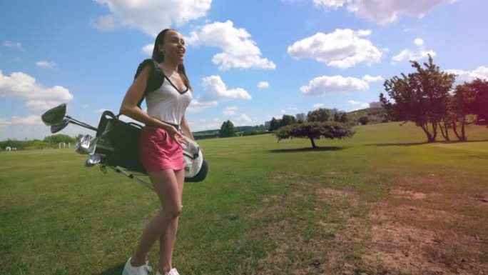 年轻的女士正在球场上携带高尔夫配件