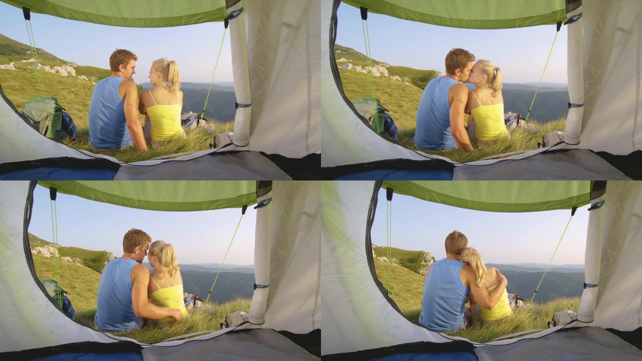 特写: 无忧无虑的旅游夫妇坐在帐篷前接吻。