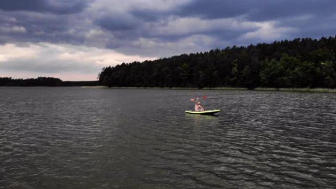 在湖上划独木舟。向摄像机挥手