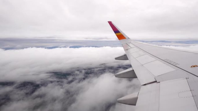 在雨季飞越云雾时从机翼的商业客机乘客窗口观看