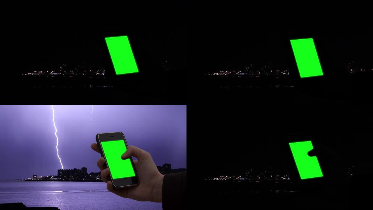 在暴风雨的夜晚，男性的手使用带有绿色屏幕的智能手机。