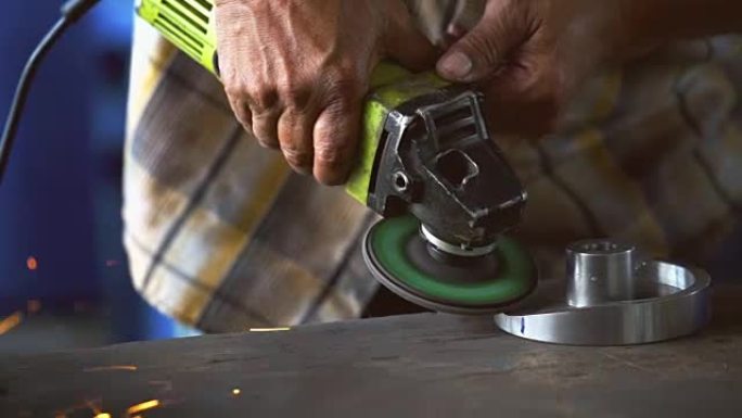 4k慢动作镜头角磨机的特写镜头在金属工厂，工业和机器概念的木桌上手持和研磨金属的备件