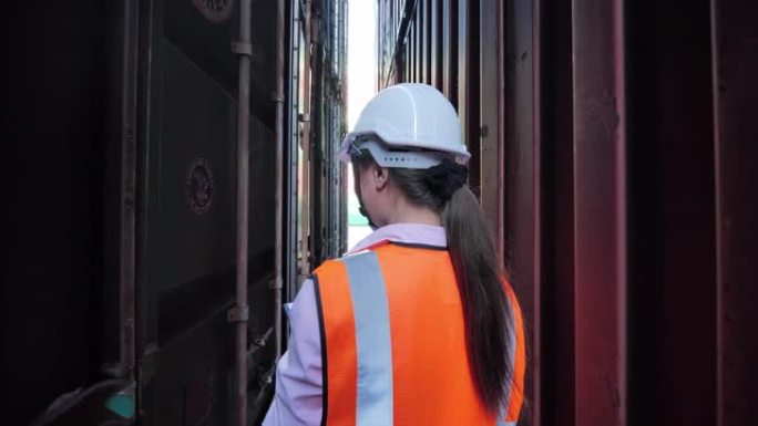 快乐的亚洲女性工程师步行检查从货物货运装载集装箱箱。技术，交付，商业，增长，连接，沟通，商业，授权，