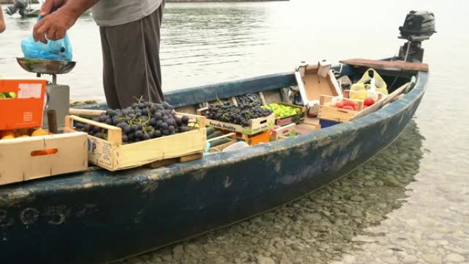 男子女士在船上向妇女出售新鲜水果