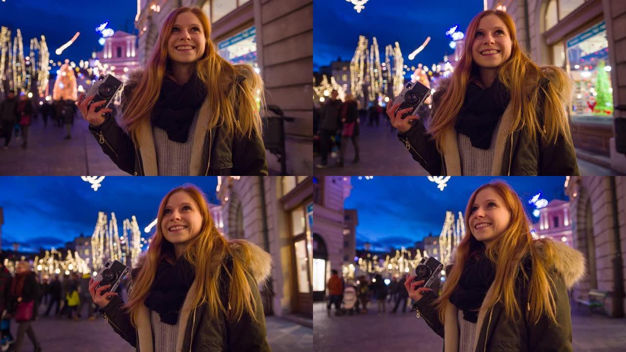 微笑的女人欣赏城市中的节日圣诞装饰品