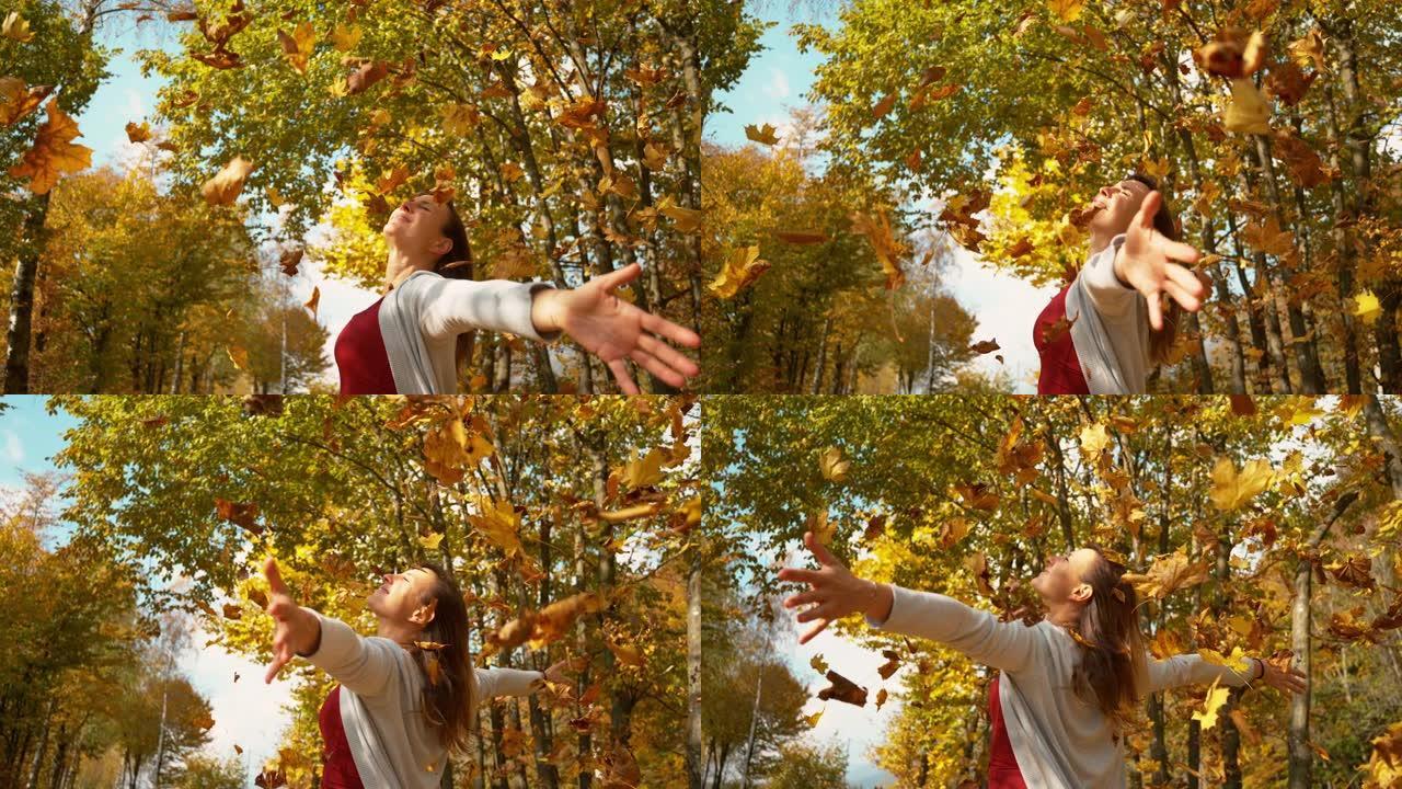 复制空间: 无忧无虑的女人让五颜六色的叶子落在她身上的电影镜头