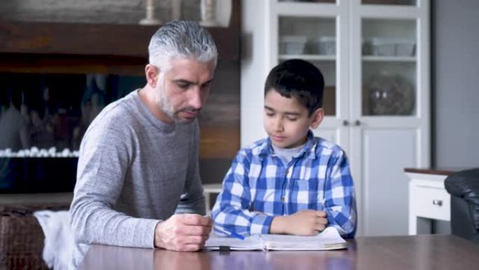 民族父亲帮助儿子做家庭作业