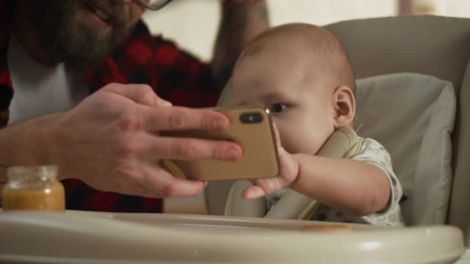父亲向婴儿展示智能手机