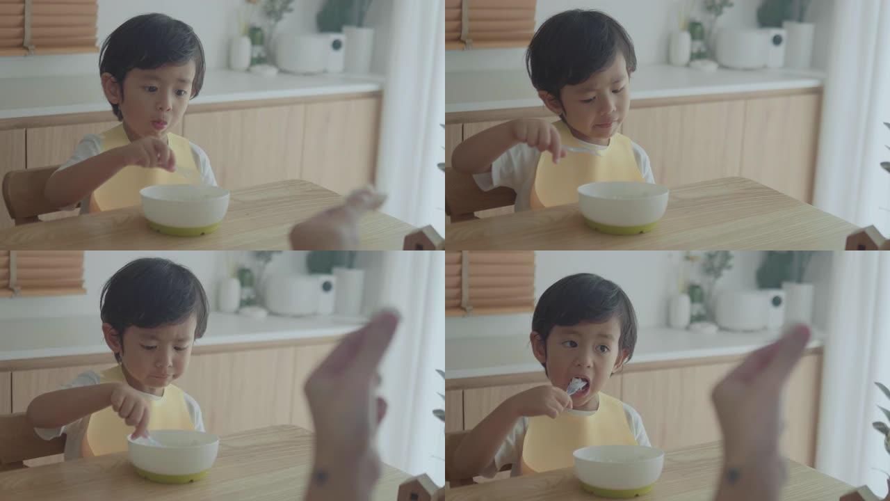 微笑的小男孩在高脚椅上吃饭