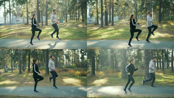 好看的年轻人的侧视图女孩和男孩在公园里做运动，在温暖阳光明媚的秋日一起在路上跑步和跳跃。自然和活动概