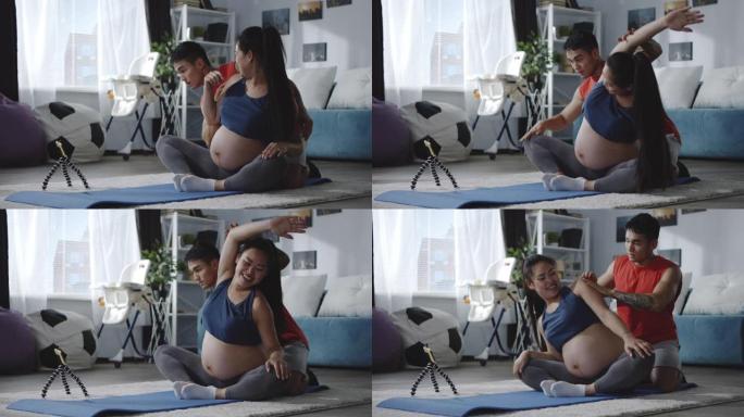 一名男子和一名孕妇在健身期间观看视频