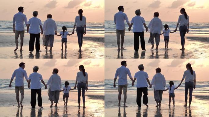 剪影快乐的亚洲大家庭步行到沙滩上日落冲浪。家庭，生活方式，人，人寿保险，多代，老人，假期，关系，孩子