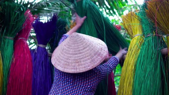 越南女工匠在越南东塔丁延老村干燥传统越南垫子的背面的4k镜头场景，传统艺术家概念