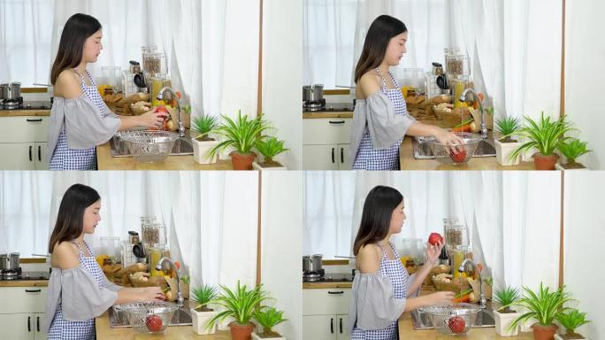 4k; 亚洲女性在厨房房间洗苹果。