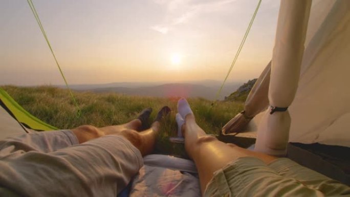 太阳耀斑: 年轻夫妇在帐篷里看日落时移动脚