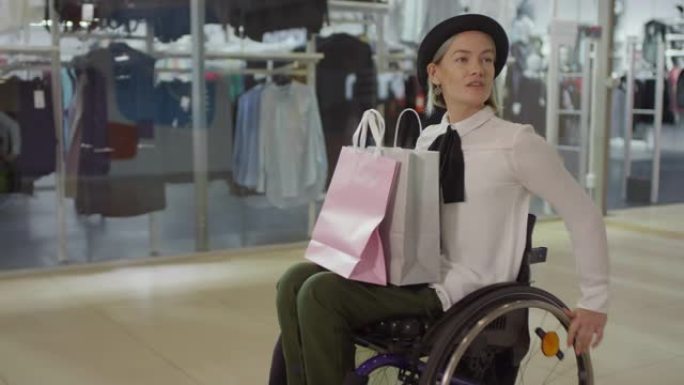坐轮椅穿过购物中心的时尚截瘫妇女