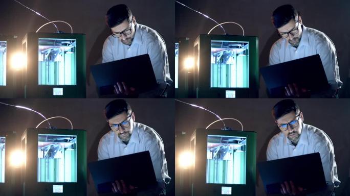 一个有笔记本电脑的人控制着3D打印机。3d打印行业研究工程师在实验室工作。