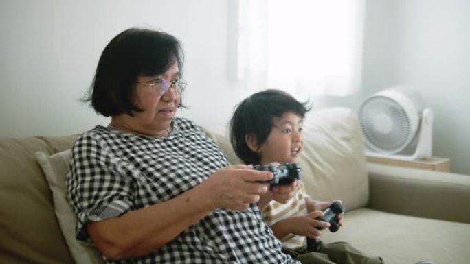 兴奋的男孩在家里与祖母竞争电子游戏