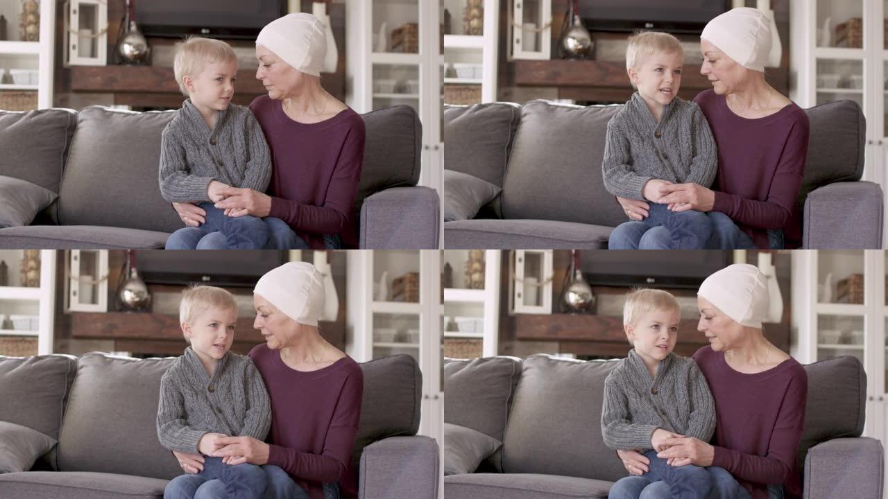 一位从癌症中康复的祖母与她的孙子在沙发上依sn。