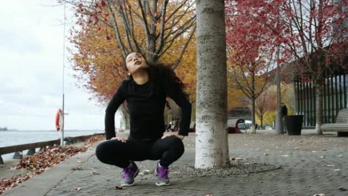 有吸引力的少数民族年轻成年女性在秋季跑步前伸展运动