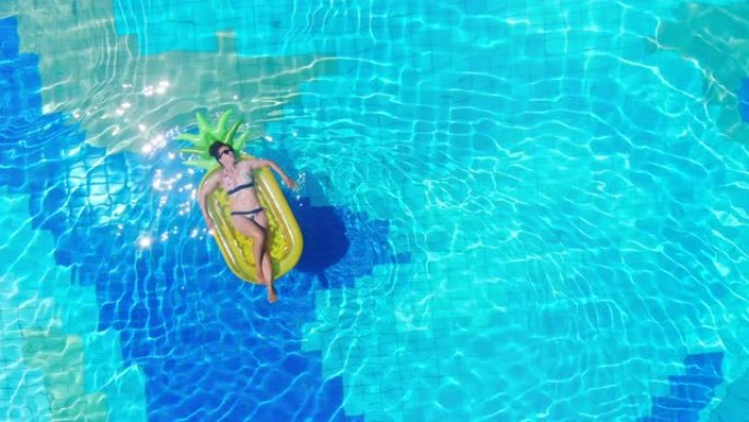 女游客躺在游泳池的充气橡胶圈上。暑假概念。
