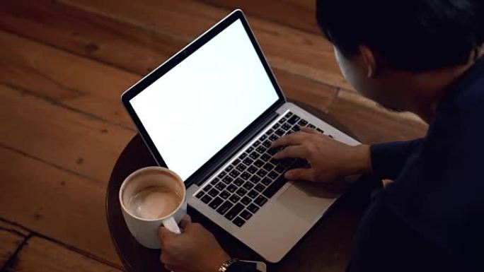4k镜头亚洲商人与休闲服装喝咖啡和与咖啡咖啡馆的白屏笔记本电脑工作的场景，生活方式和休闲概念