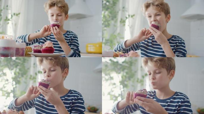 在厨房里: 可爱的男孩吃奶油蛋糕，糖霜和撒上Funfetti。可爱的饥饿的甜食孩子咬成松饼，含糖糖霜