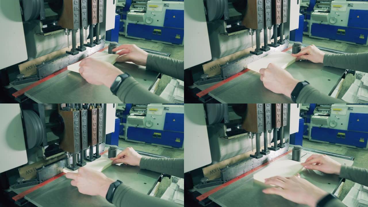 排版工人正在使用机器在纸上打孔