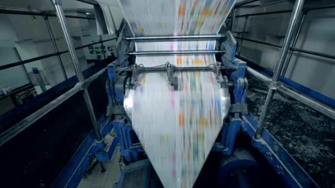 彩色报纸在印刷输送机上移动，印刷办公室。