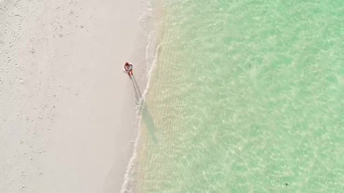 MS到WS女人走在阳光明媚的田园诗般的热带海滩上，马尔代夫