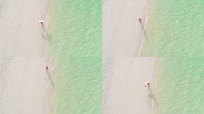 MS到WS女人走在阳光明媚的田园诗般的热带海滩上，马尔代夫