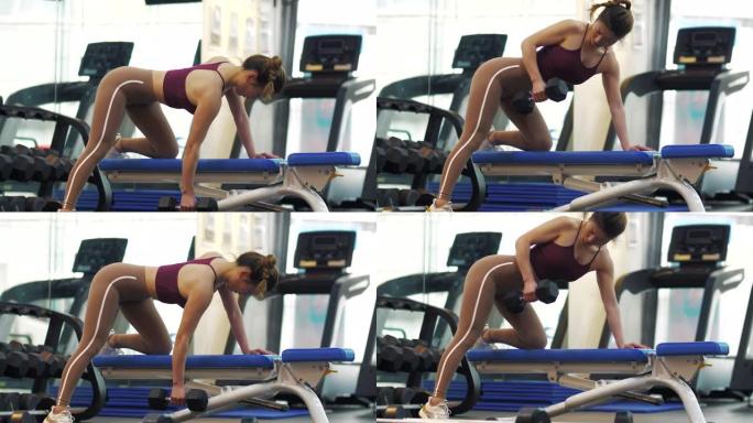 一个美丽的年轻亚洲女孩在健身房锻炼的侧视图