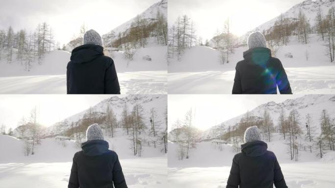 在冬天的日子里，一个美丽的女人在山上玩雪，呼吸着沉浸在大自然中的清洁空气。