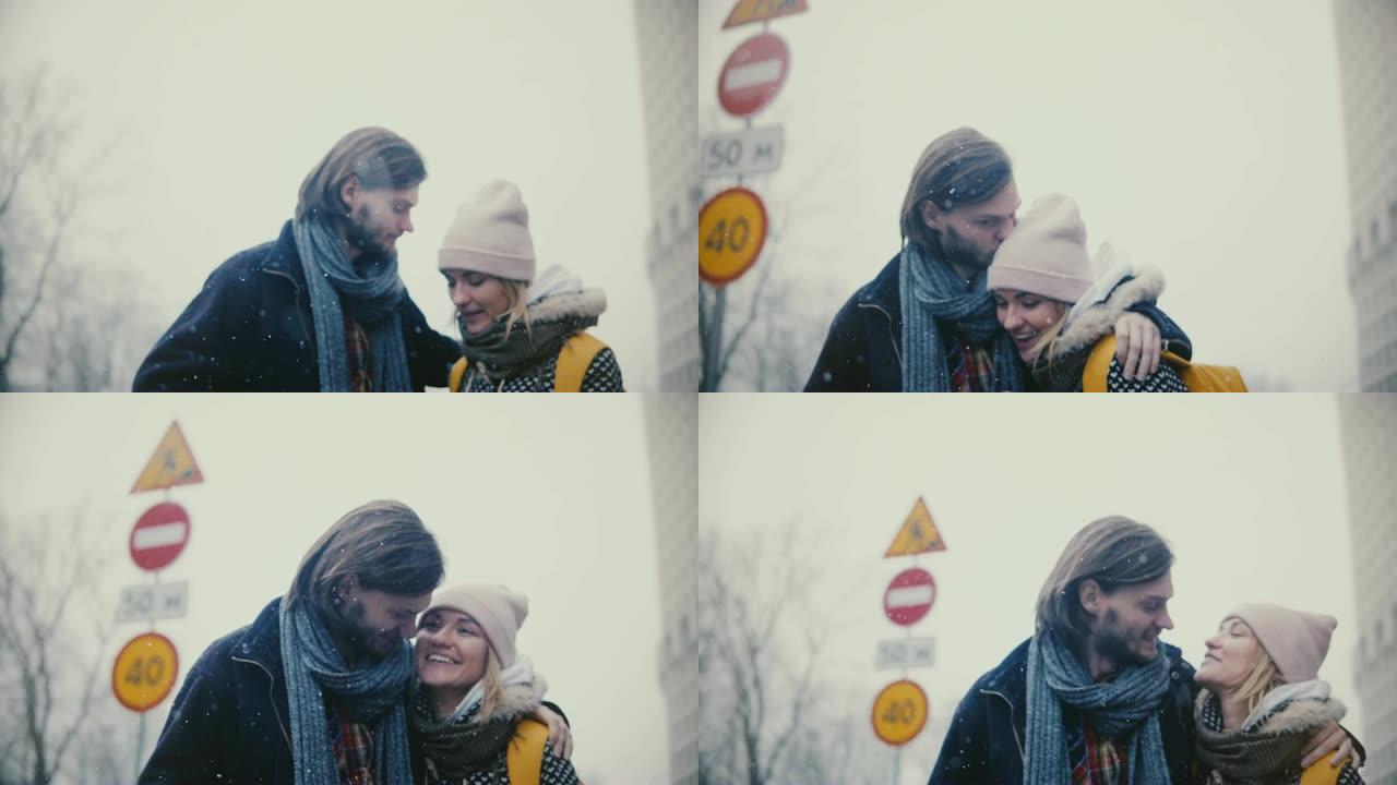 快乐轻松的年轻浪漫情侣穿着休闲暖和的衣服走在一起，在一个下雪的冬天圣诞节拥抱和亲吻。