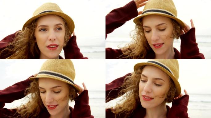 海滩上戴着帽子的年轻美丽高加索女人的前视图4k