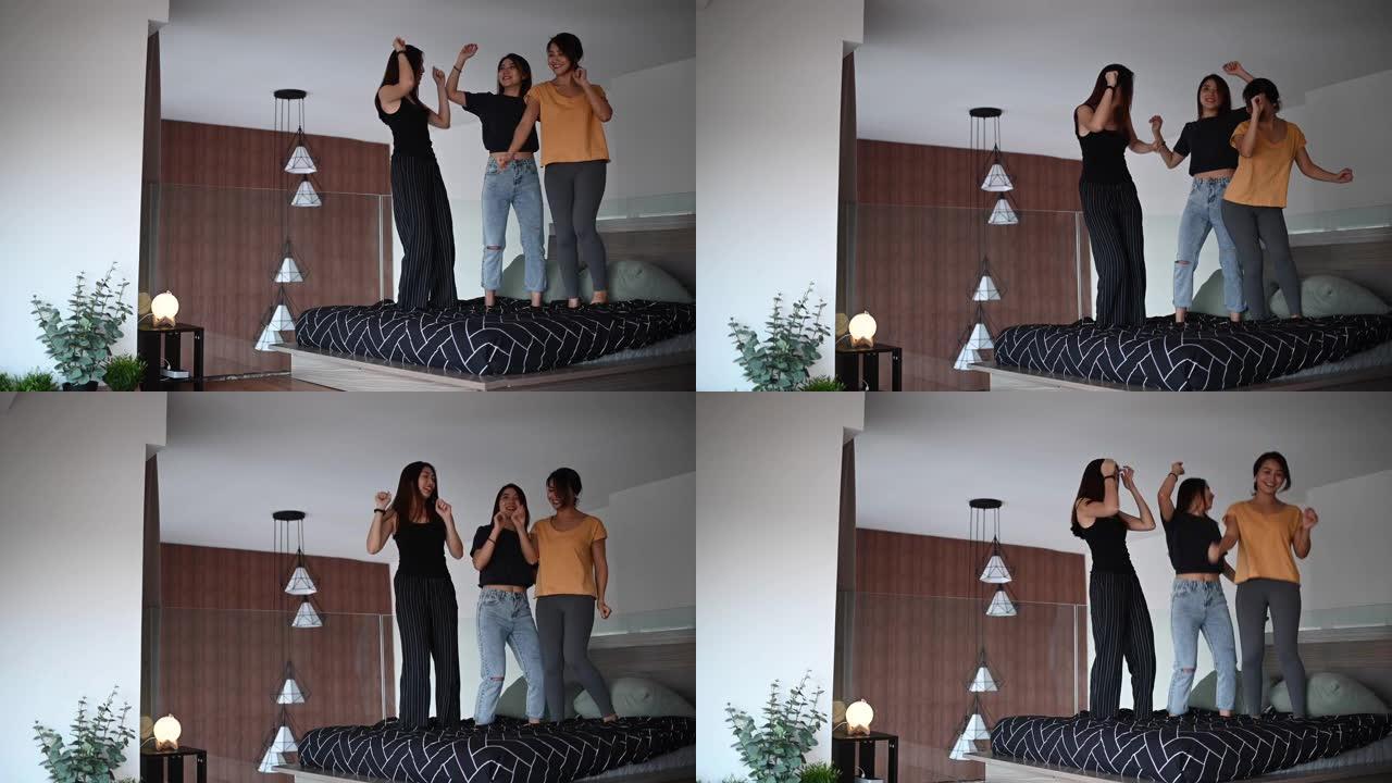 亚洲华裔女性朋友在卧室的床上跳舞，玩得开心，听音乐，一起享受快乐的时刻