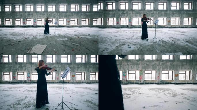 一名妇女拉小提琴的废弃建筑