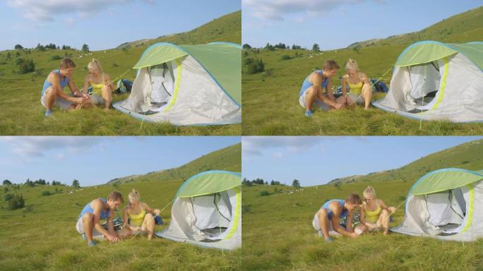 慢动作: 微笑的年轻女子在男友搭帐篷时协助他。