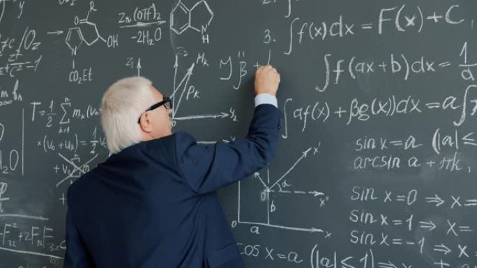 大学教授在课堂上在黑板上写公式的慢动作