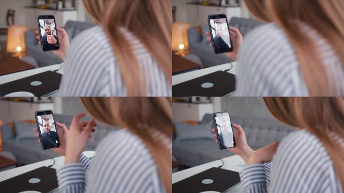 POV特写年轻的白人女性使用智能手机在线视频通话在自我隔离上与开朗的男性朋友交谈。