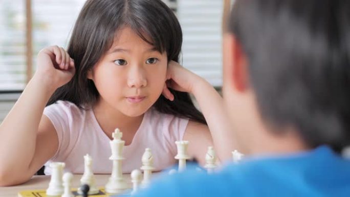 两个可爱的孩子在家里下棋。孩子欢喜赢了一盘棋，悲伤的对手遮住了脸，沮丧的失败。商业理念和思维在玩g 