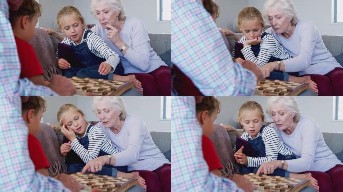 祖父母在家与孙子玩吃水的棋盘游戏