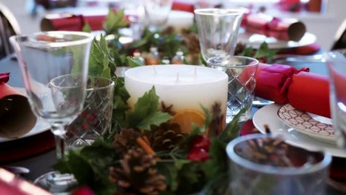 在餐桌上倾斜白色蜡烛的镜头，为圣诞节晚餐做准备，细节，选择性聚焦