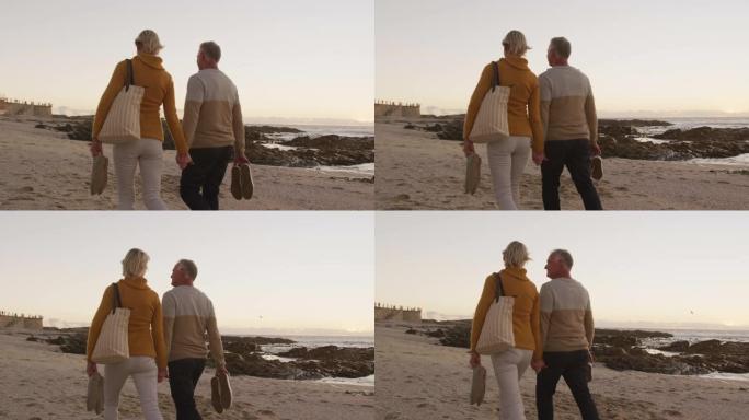 一对老年夫妇在海滩上手拉手