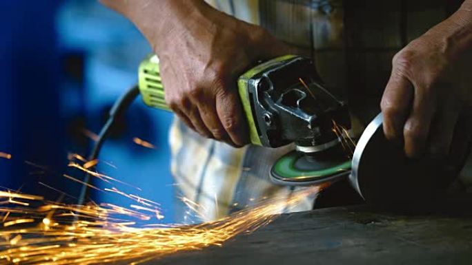 4k镜头场景角磨机的特写在金属工厂，工业和机器概念中手持和研磨木桌上的金属备件