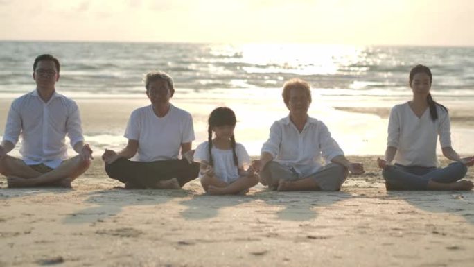 一个大家庭在沙滩上做瑜伽到日落冲浪的剪影。家庭，生活方式，人，人寿保险，多代，老人，假期，关系，孩子