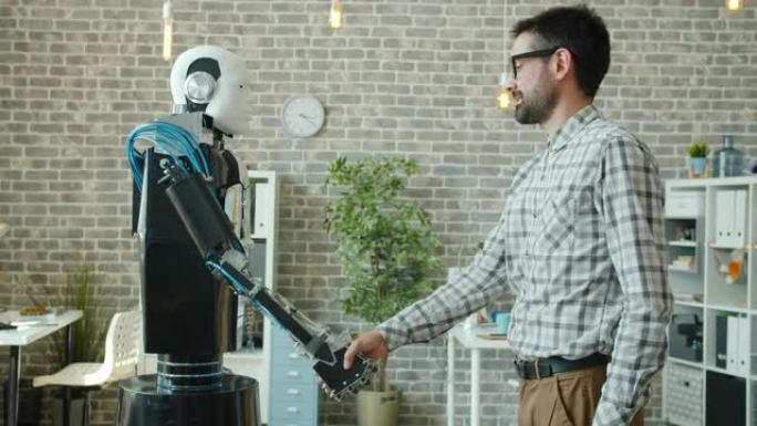 微笑的家伙与喜欢人工智能的机器人握手