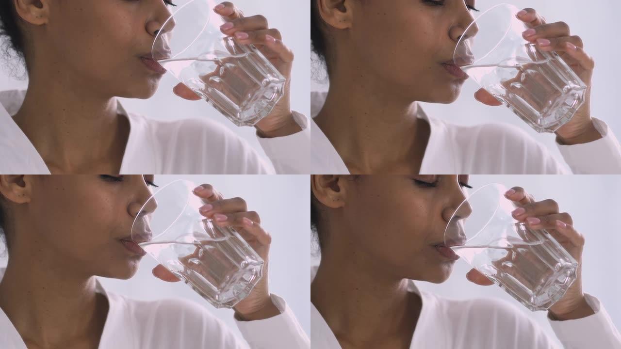 渴了的非洲女人早上拿着杯子喝水，特写镜头