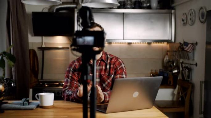 快乐的年轻微笑技术博客作者用专业相机在家庭厨房慢动作制作vlog视频流。
