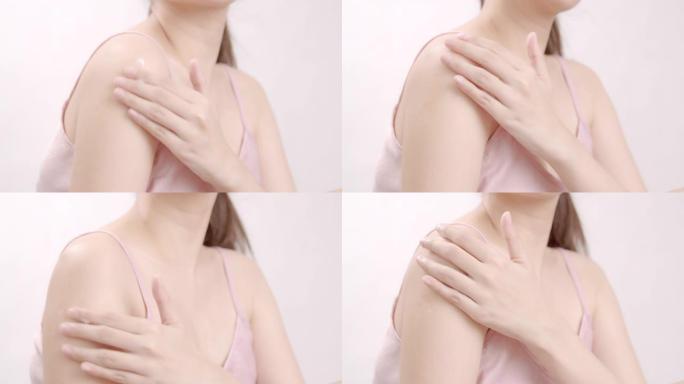 亚洲成年女性用手在肩膀上涂抹保湿霜。身体护理概念。